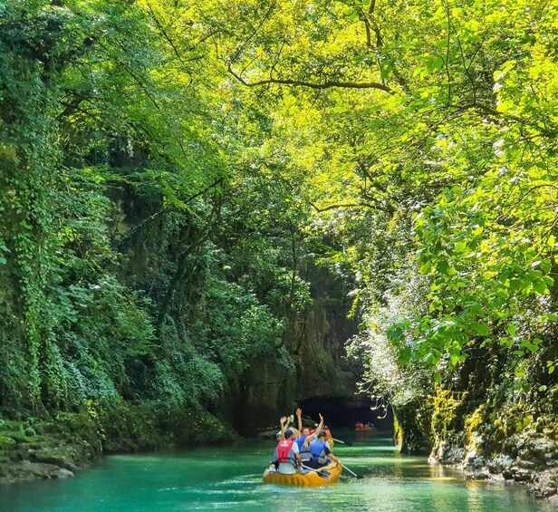 A group of people rafting down a river surrounded by dense greenery. 4