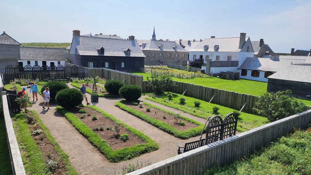 A garden with pathways, a wooden fence, and traditional buildings. 3
