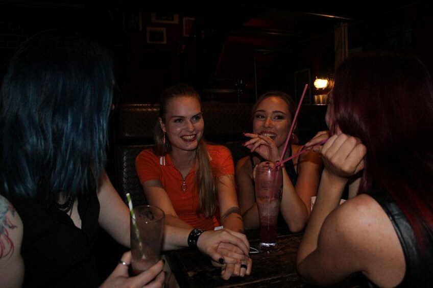 Cuatro personas sentadas en una mesa con bebidas. 1