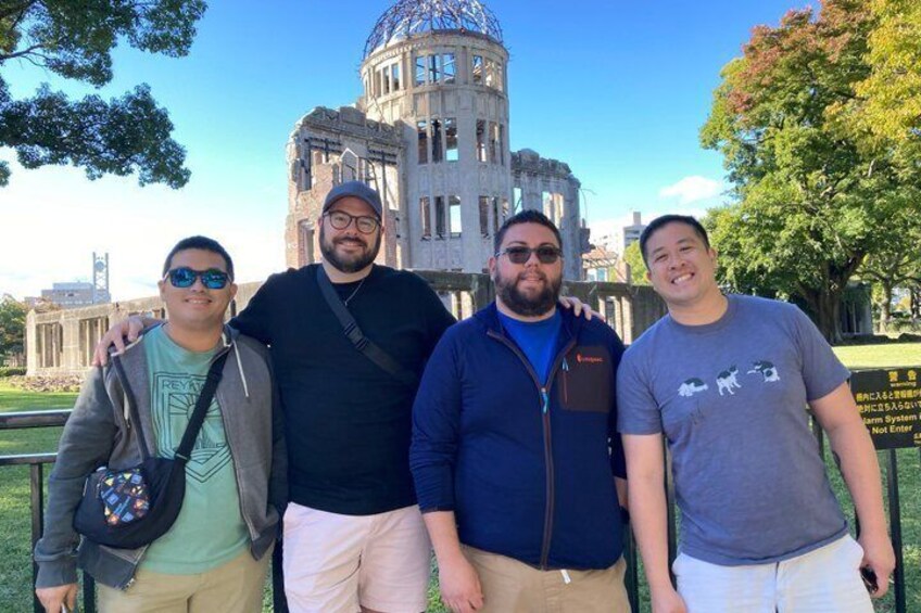 Four people standing in front of a large building with a dome and columns. 5