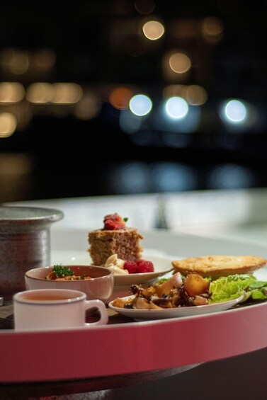 A dessert tray with various sweets and a cup of tea. 2