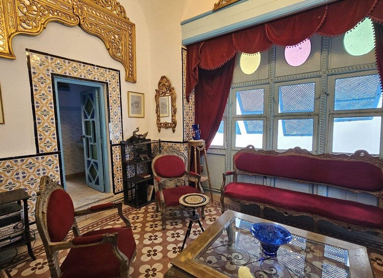 A room with ornate furniture, a patterned floor, and a large window with curtains. 3
