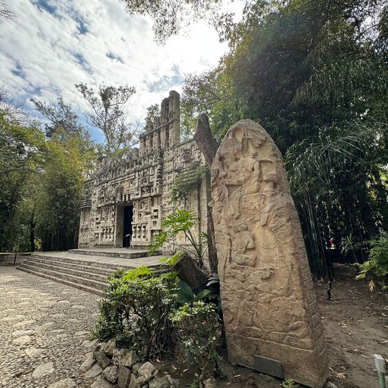 A stone temple with intricate carvings, surrounded by lush greenery and a clear sky. 5