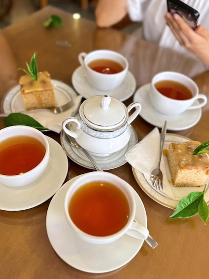 A table with tea cups, saucers, and a teapot. 5