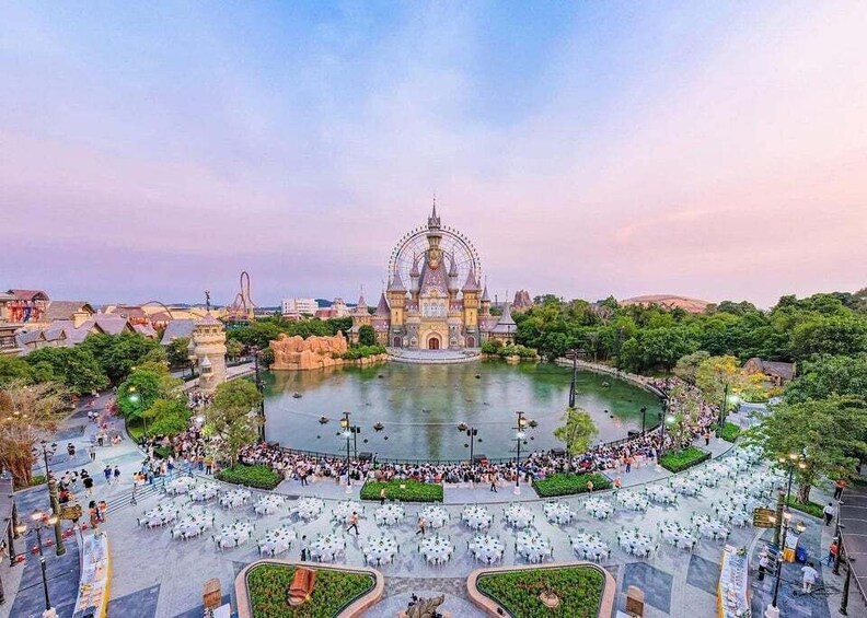 A large park with a central fountain, surrounded by tables and chairs, and a Ferris wheel in the background. 3
