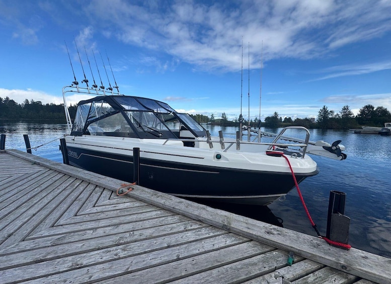 A boat docked at a wooden pier with a clear sky and calm water. 4