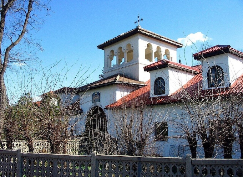 A church with a bell tower, arched windows, and a red-tiled roof. 1