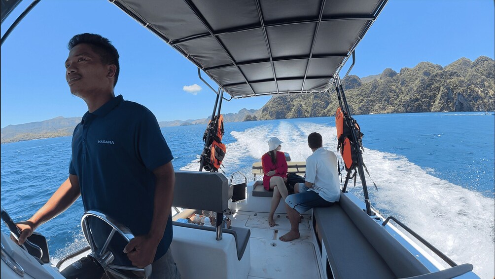A boat with a canopy, passengers, and a mountainous coastline. 4