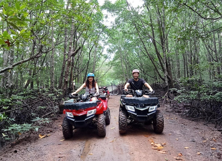 Two people on ATVs on a forest trail. 4
