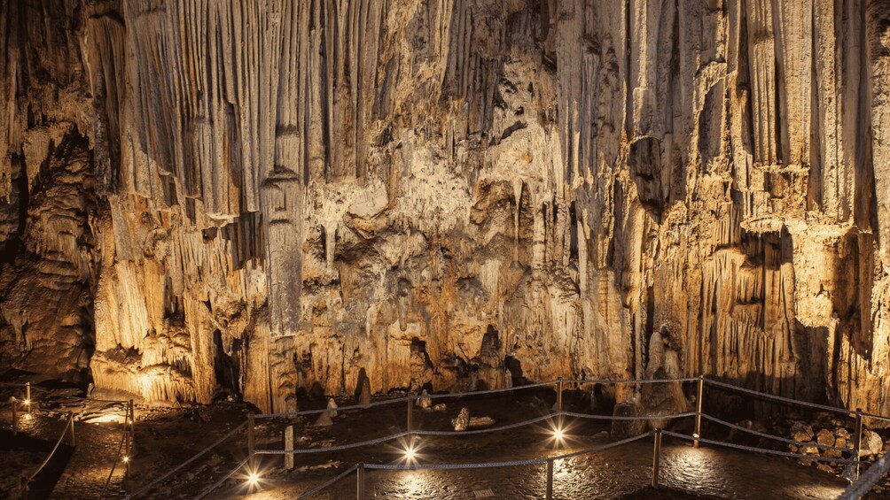 A cave interior with stalactites and a rope barrier. 2
