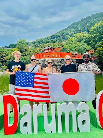 A group of people holding flags in front of a sign that reads 'Daruma.' 5