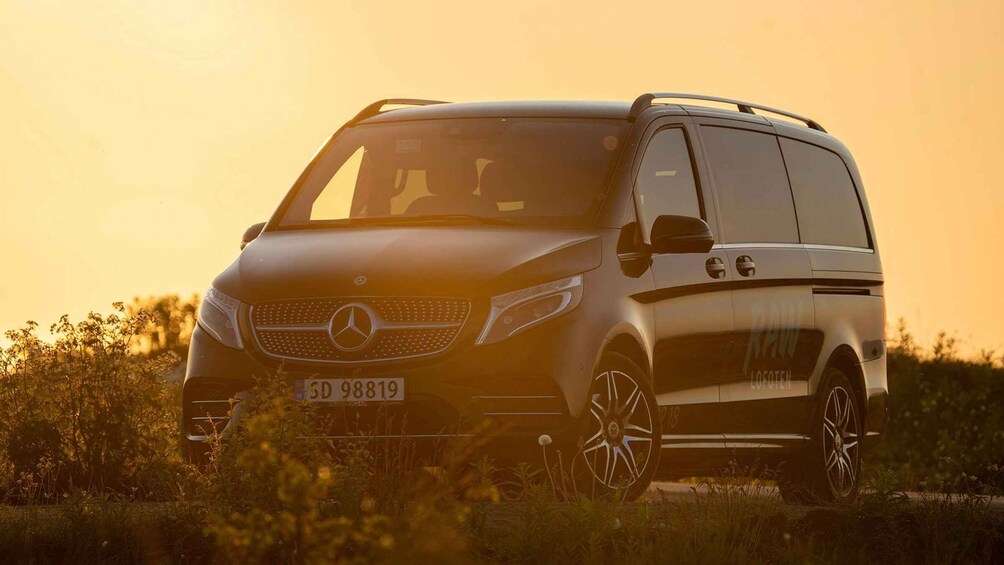 A Mercedes-Benz Sprinter van parked in a field with a sunset in the background. 5