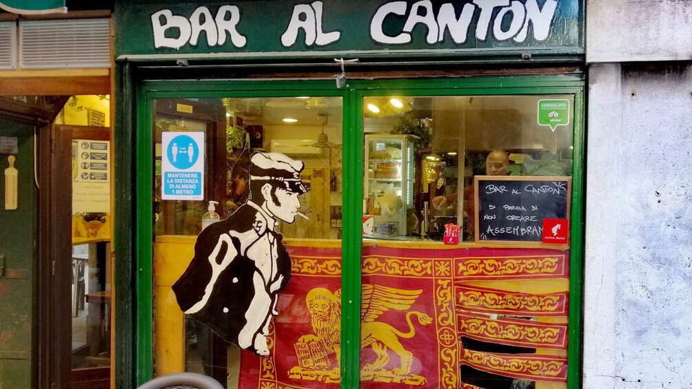 A storefront with a sign reading 'BAR AL CANTON' and a mural of a man with a beard and a hat. 4