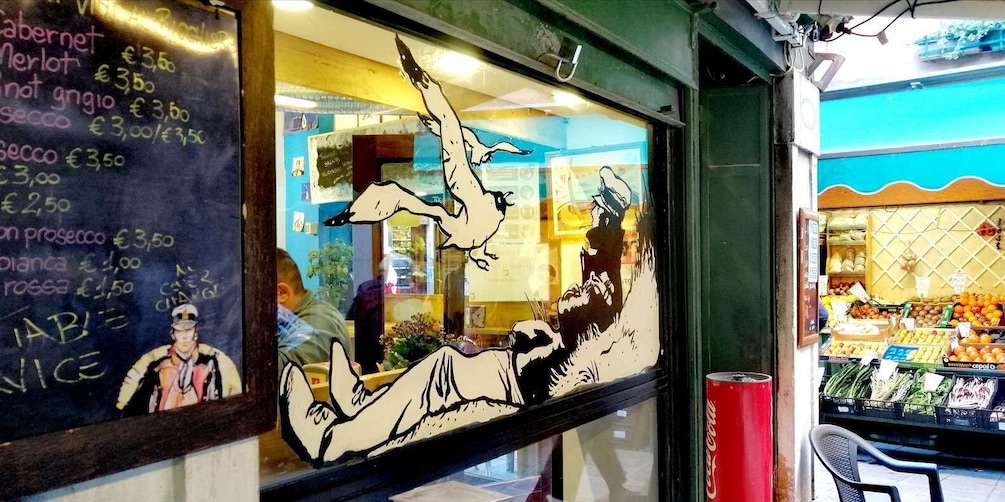 A chalkboard menu with various food items and prices, a window with a cartoon drawing, and a fruit stand outside. 3