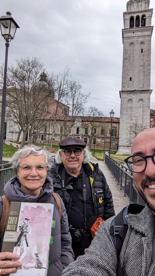Three people on a bridge with a historic tower in the background. 5