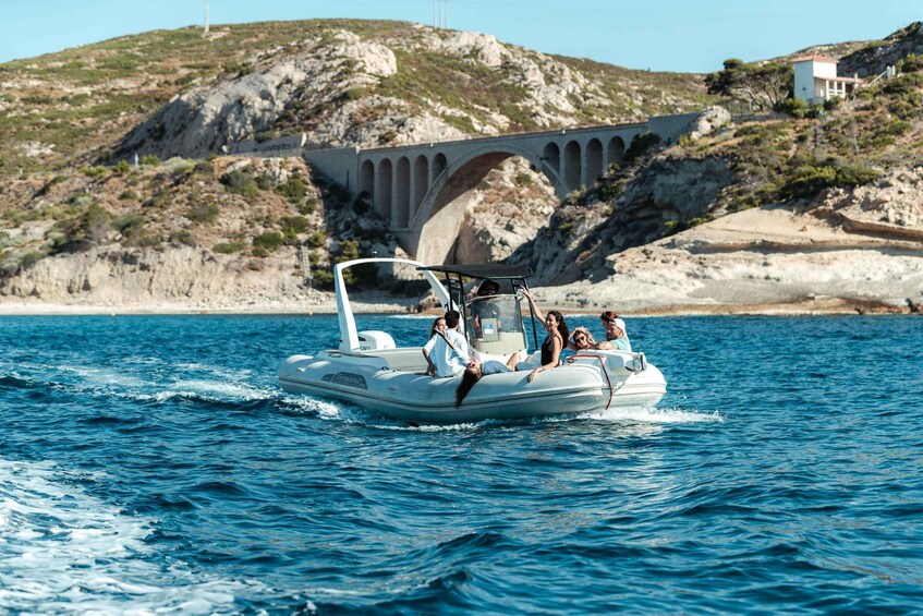 A group of people on a motorboat in a body of water with a bridge in the background. 2