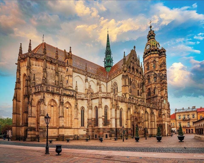 A historic cathedral with intricate architecture, a clock tower, and a clear sky. 1