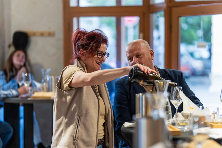 A person pouring a drink into a glass at a restaurant. 4