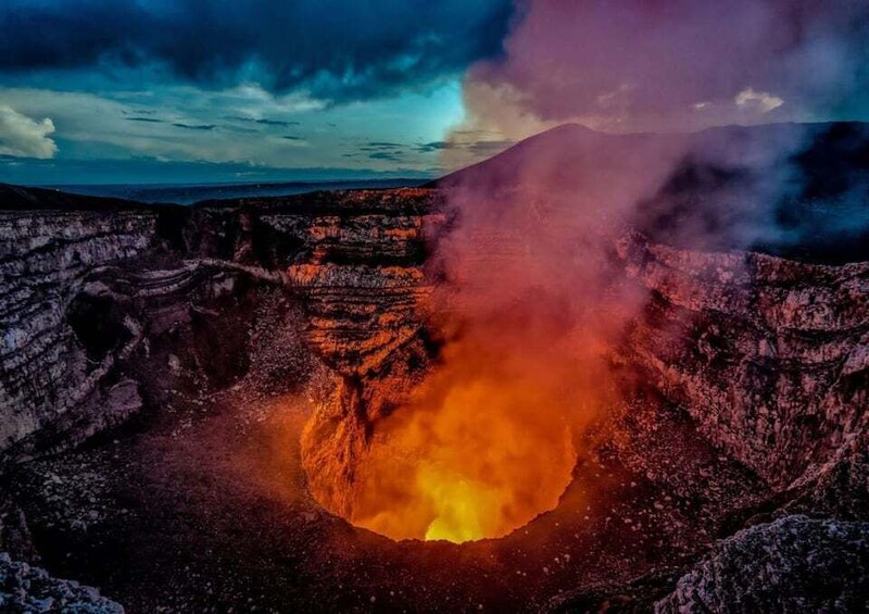 A volcanic crater with glowing lava and smoke. 1