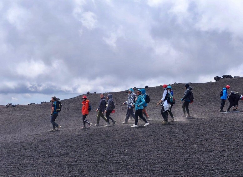 A group of hikers ascending a volcanic slope. 5