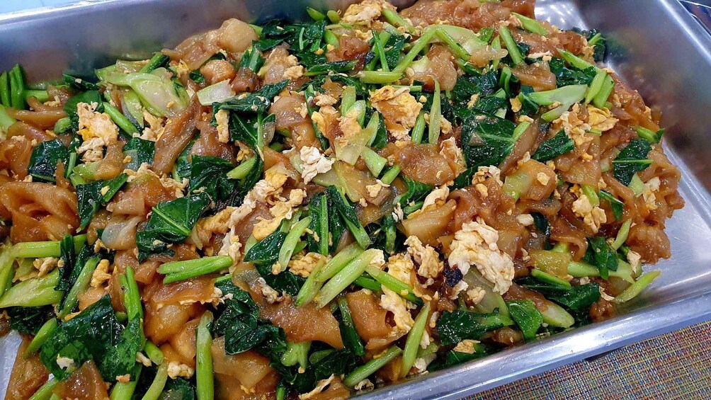 A dish with stir-fried vegetables and scrambled eggs in a metal tray. 4