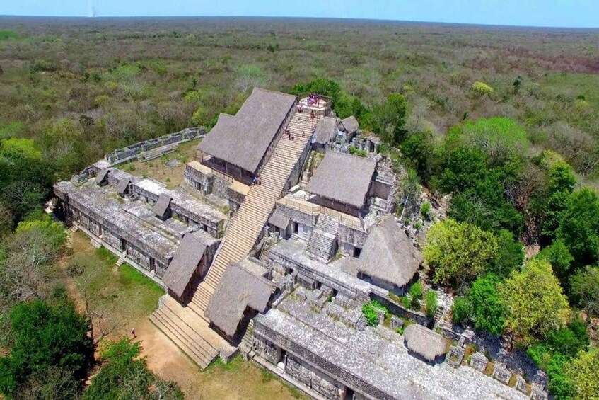 An ancient Mayan pyramid complex surrounded by dense vegetation. 1