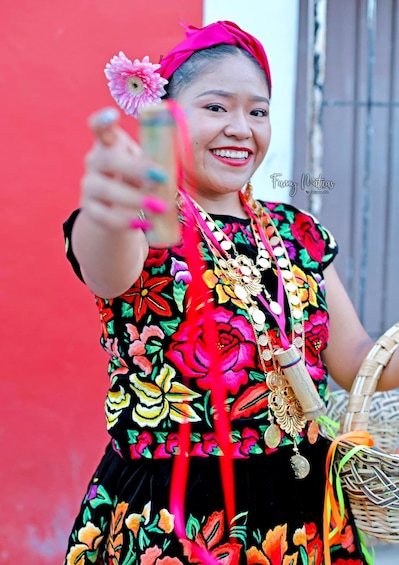 A person in a colorful floral dress with a red headband, holding a smartphone. 3