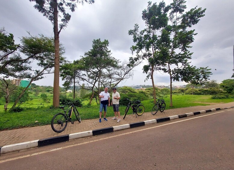 Two people standing by a road with bicycles parked on the side. 5