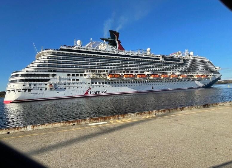 A large cruise ship named 'Carnival Magic' docked at a port. 3
