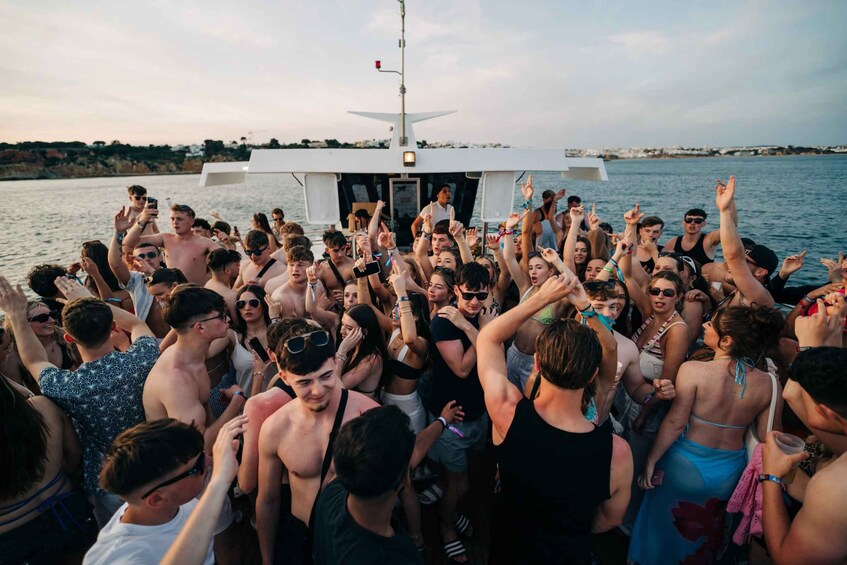 A group of people on a boat with raised hands, likely celebrating or cheering. 1