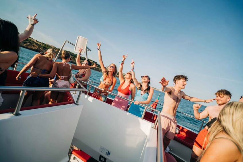 A group of people on a boat, some wearing swimsuits, with a clear sky and water in the background. 3