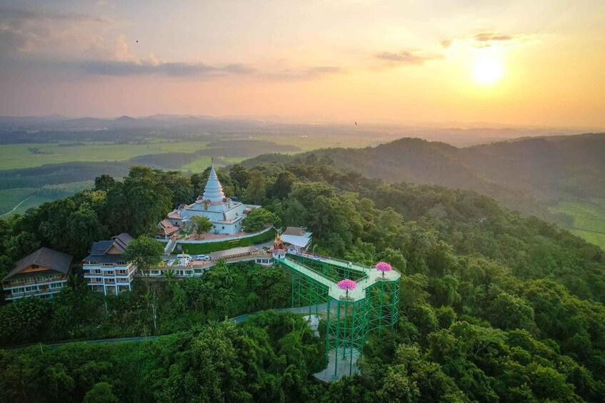 A white pagoda surrounded by lush greenery and a bridge. 3
