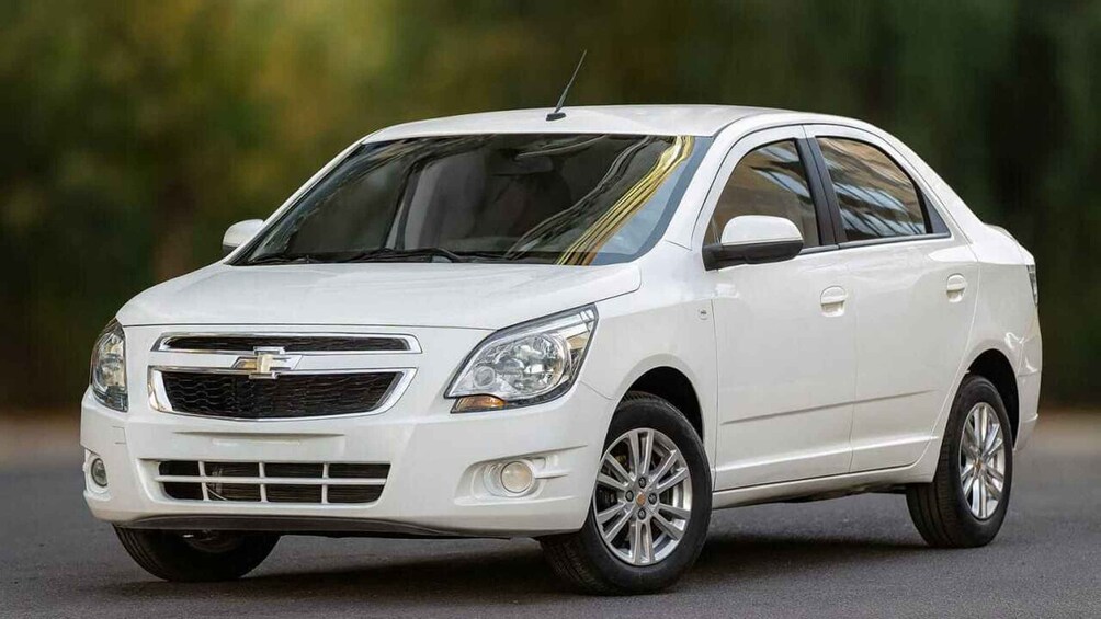 A white Chevrolet car with a sunroof, chrome grille, and alloy wheels. 1