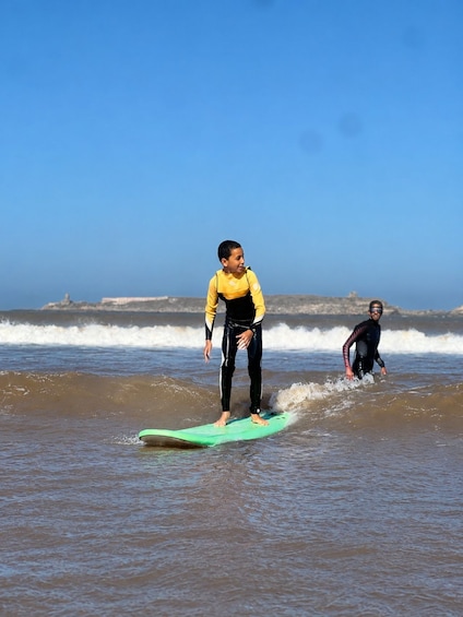 A person surfing on a green board in the ocean with waves. 4
