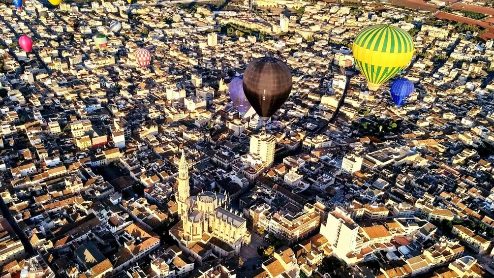 A cityscape with numerous hot air balloons. 1