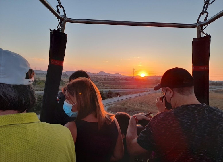 A group of people on a cable car with a sunset in the background. 2