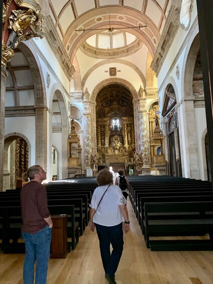 An ornate church interior with high ceilings, arched windows, and detailed gold decorations. 4