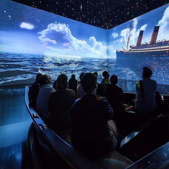 An indoor exhibit with a large screen displaying a ship and ocean scene. 1