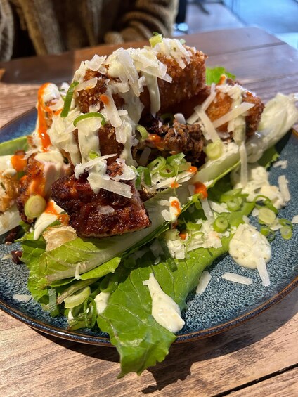 A plate of food with a salad and a meat dish. 1