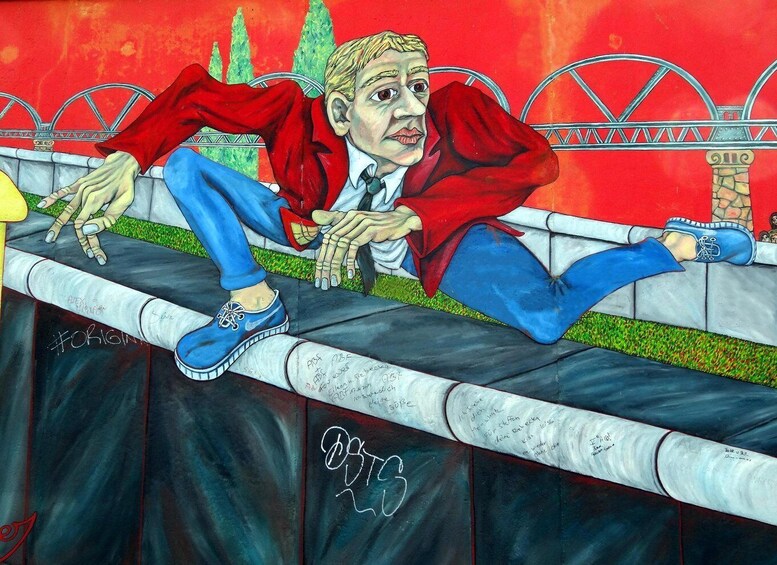 A person lying on a ledge with a bridge and trees in the background. 5