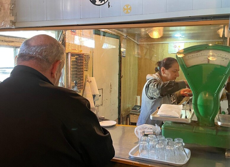 A person pouring a green liquid from a funnel into a container. 5