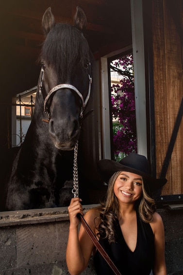 A person with a horse in a stable. 2