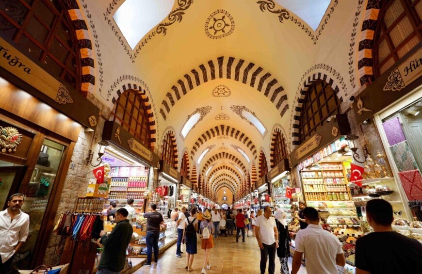 A bustling indoor market with arches and a high ceiling. 3