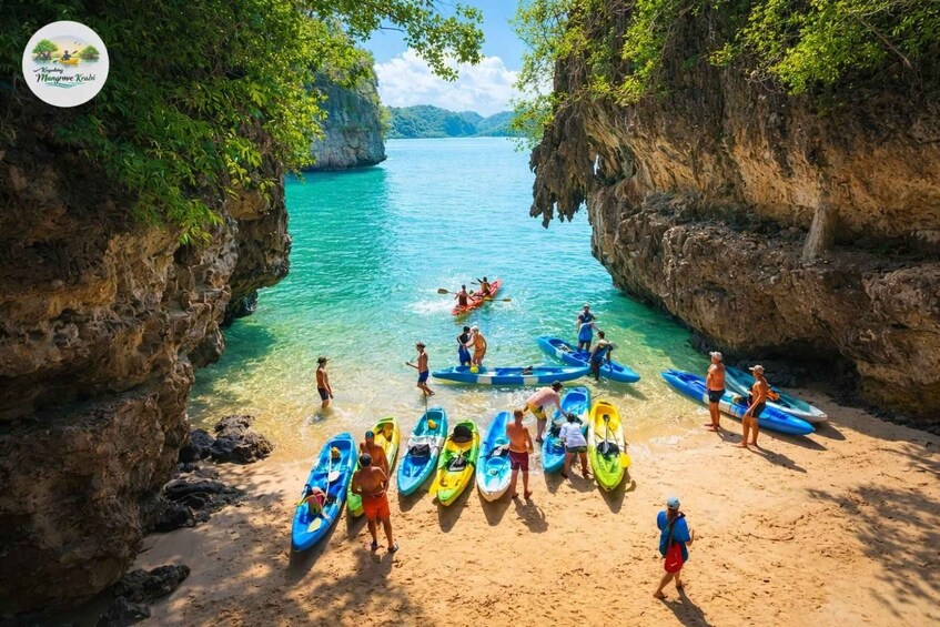 A beach with kayaks lined up and people preparing for water activities. 2