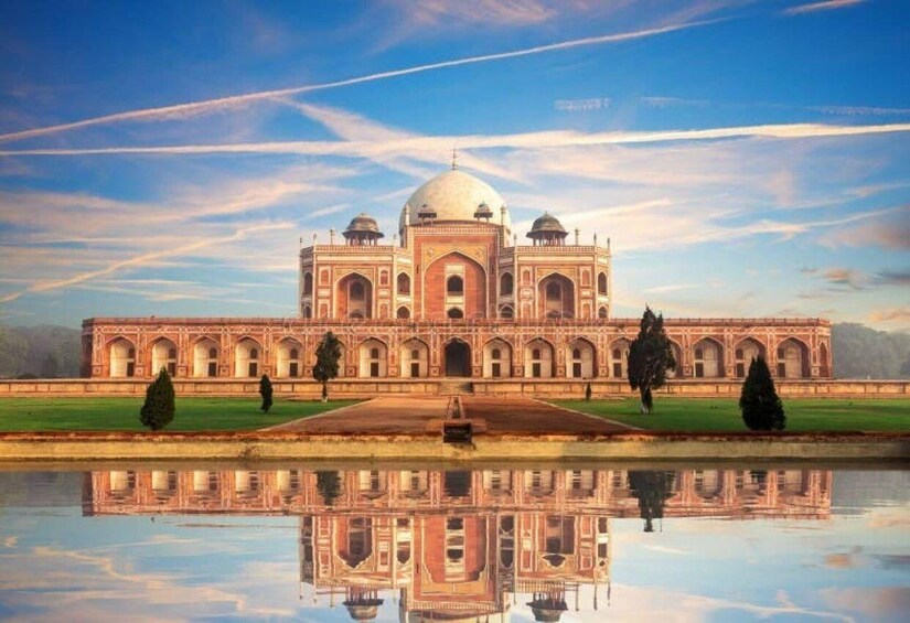 A large, symmetrical building with a central dome, surrounded by a reflective water body and greenery. 2