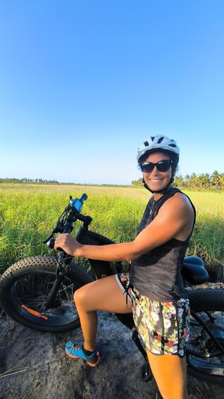 A person on a bicycle in a field with a clear sky. 5