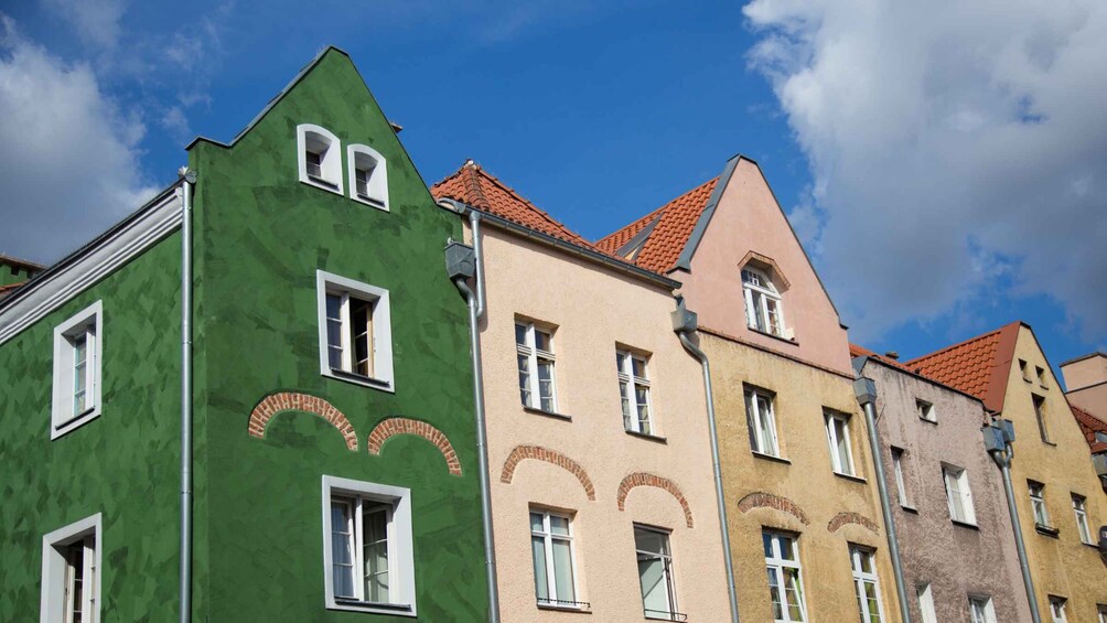 A row of colorful buildings with distinct architectural styles and red-tiled roofs. 3