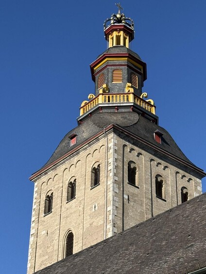 A historic building with a prominent tower featuring a spire and a clock. 3