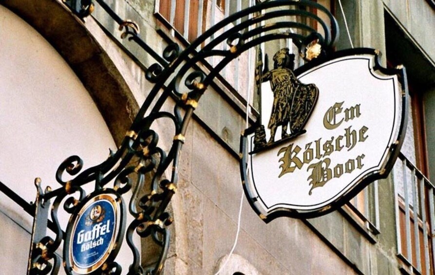 A building with a sign that reads 'Em Kolsche Boor' and a beer sign for 'Gaffel Kolsche.' 2