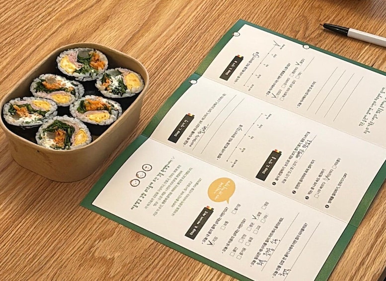 A menu with sushi rolls and a pen on a wooden table. 5